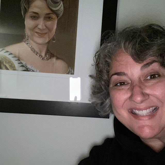 Happy customer close to her customized queen portrait from her photo. Choose your royal costume and from your photo we will create your Historical Painting