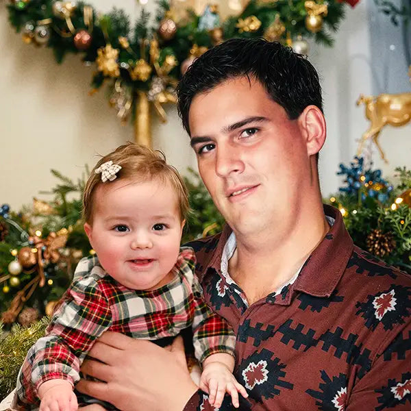 Deceased father added to a Christmas photo, holding his baby daughter by the tree