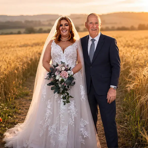 Bride's deceased father added to her wedding photo, standing at her side in a sunlit field