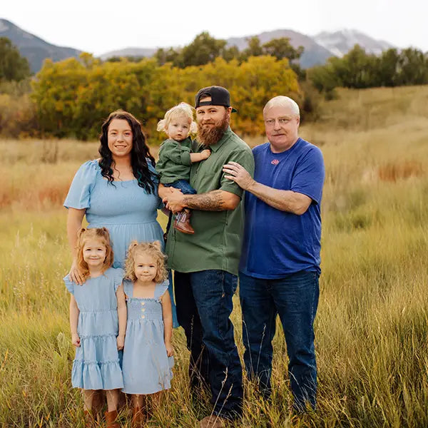 Deceased grandfather added to an outdoor family reunion photo with his grandchildren and their parents